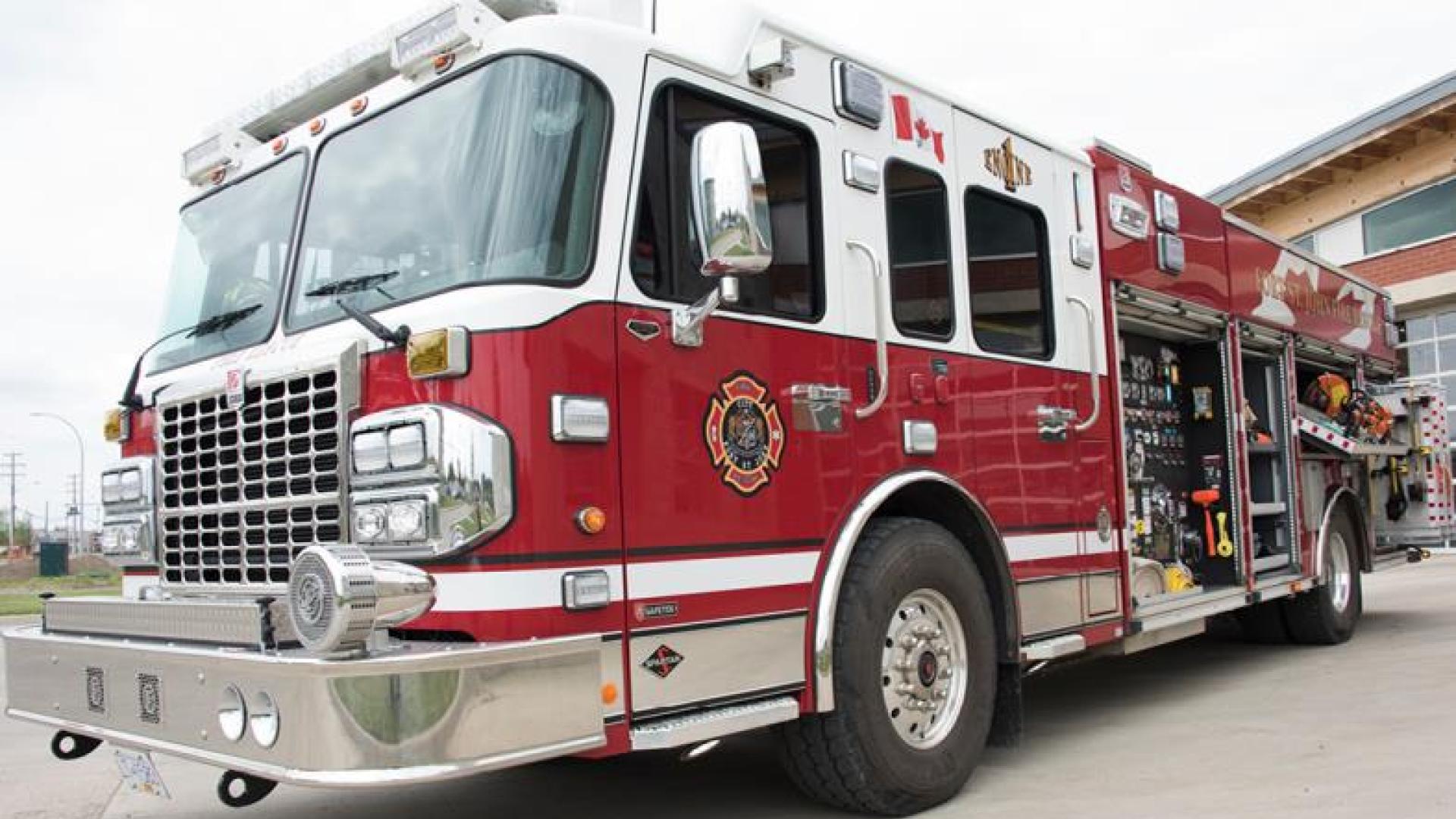 Red firetruck parked outside of fire station.
