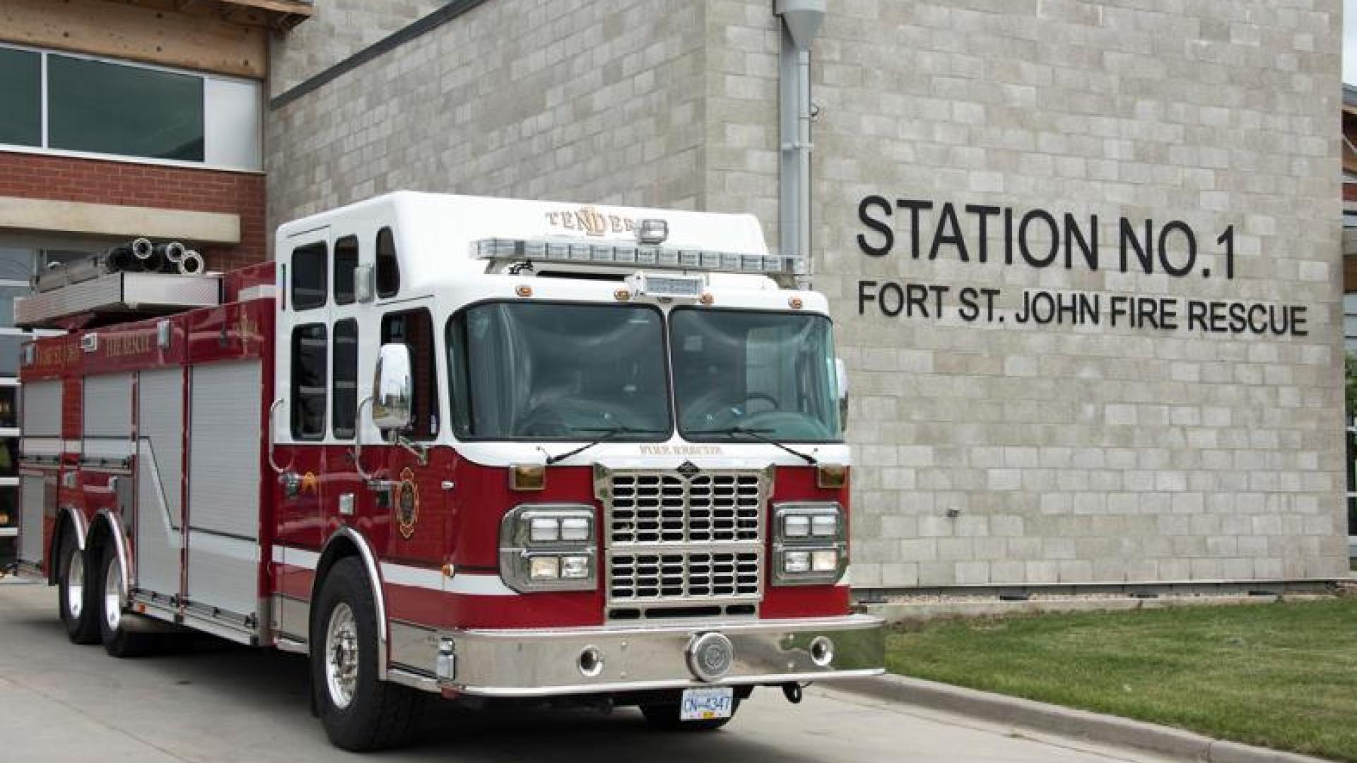Firetruck parked in front of fire station.