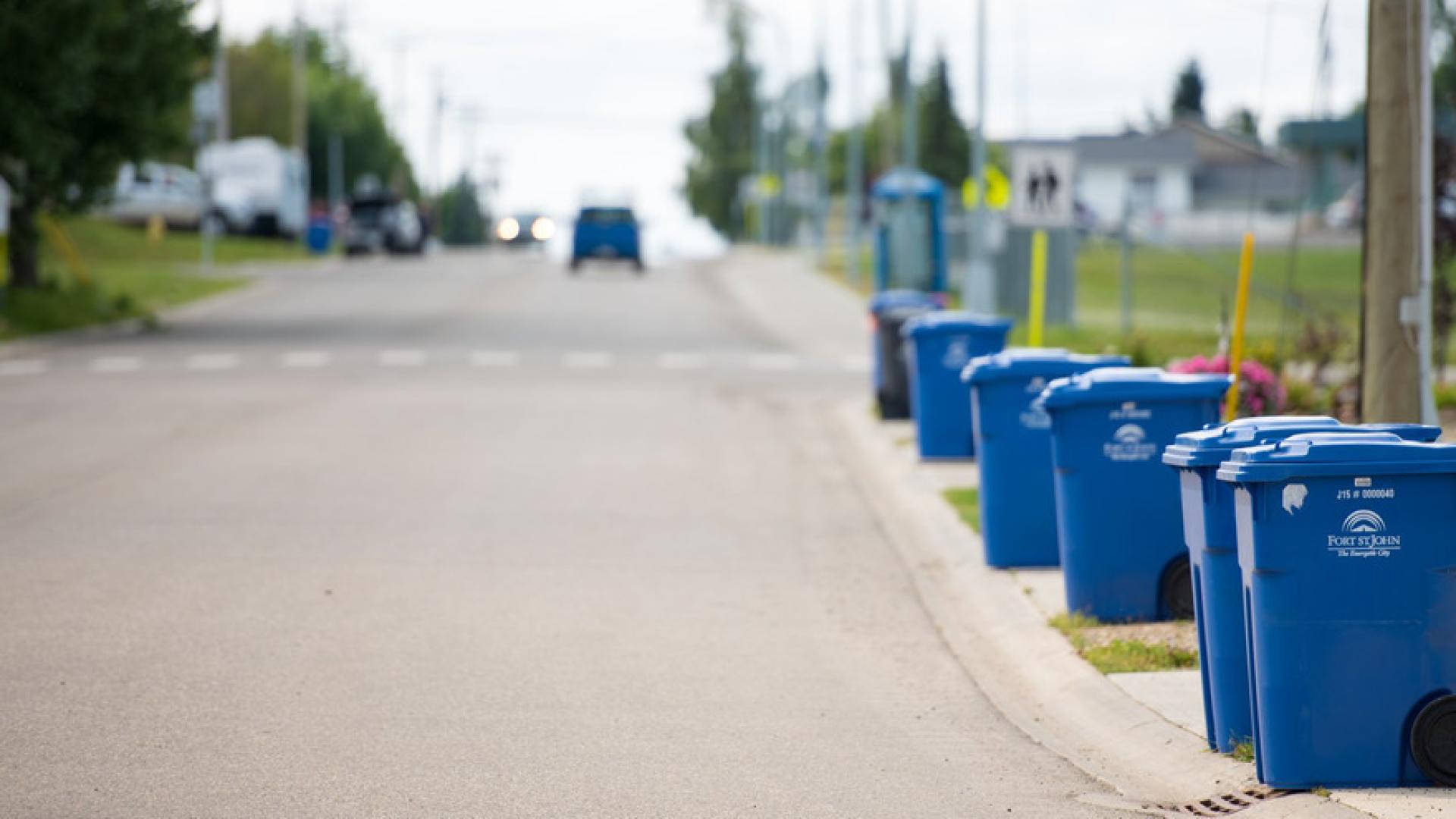 A row of recycling carts along a street.