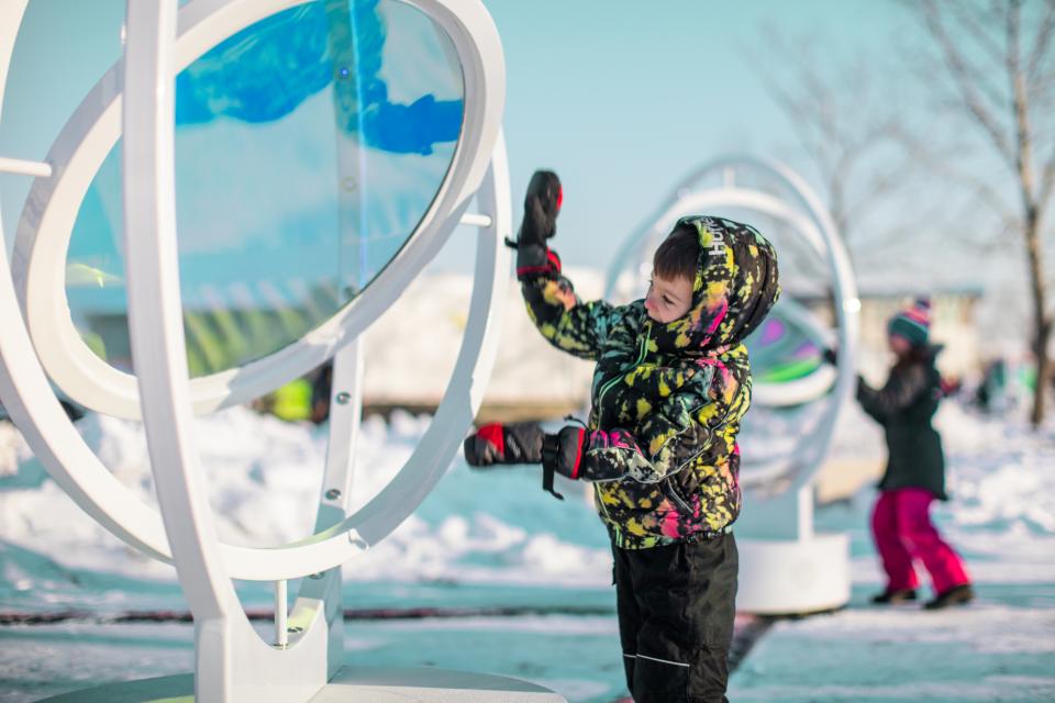 A child interacts with the Optik temporary art installation during the High on Ice Winter Festival.